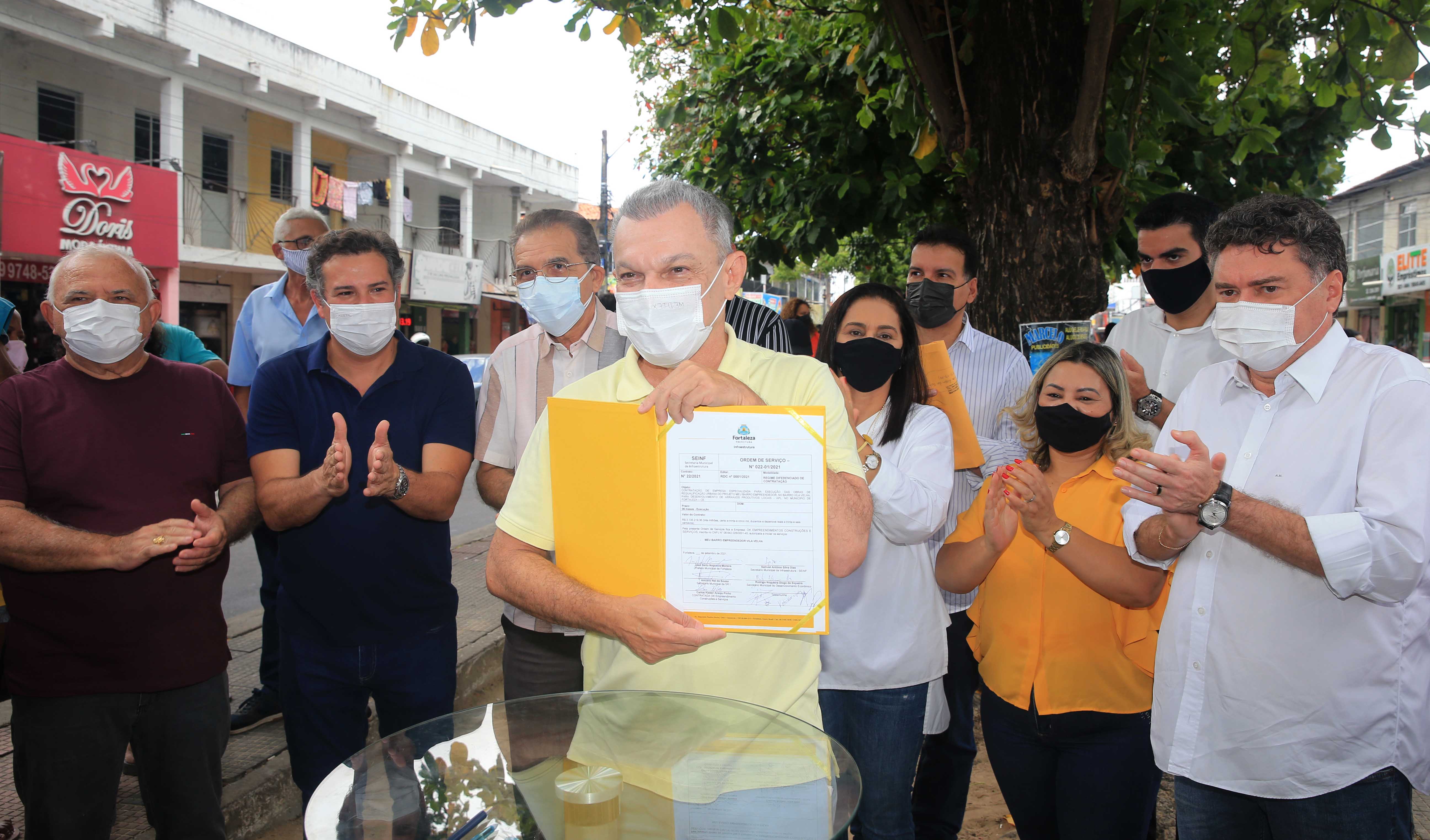 prefeito exibe o documento da ordem de serviço das obras